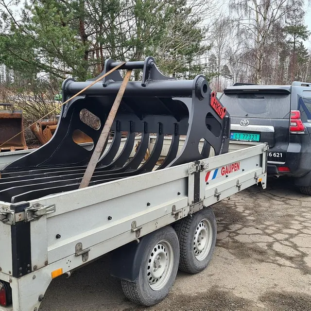 Sort riveaggregat lastet på tilhenger bak svart bil